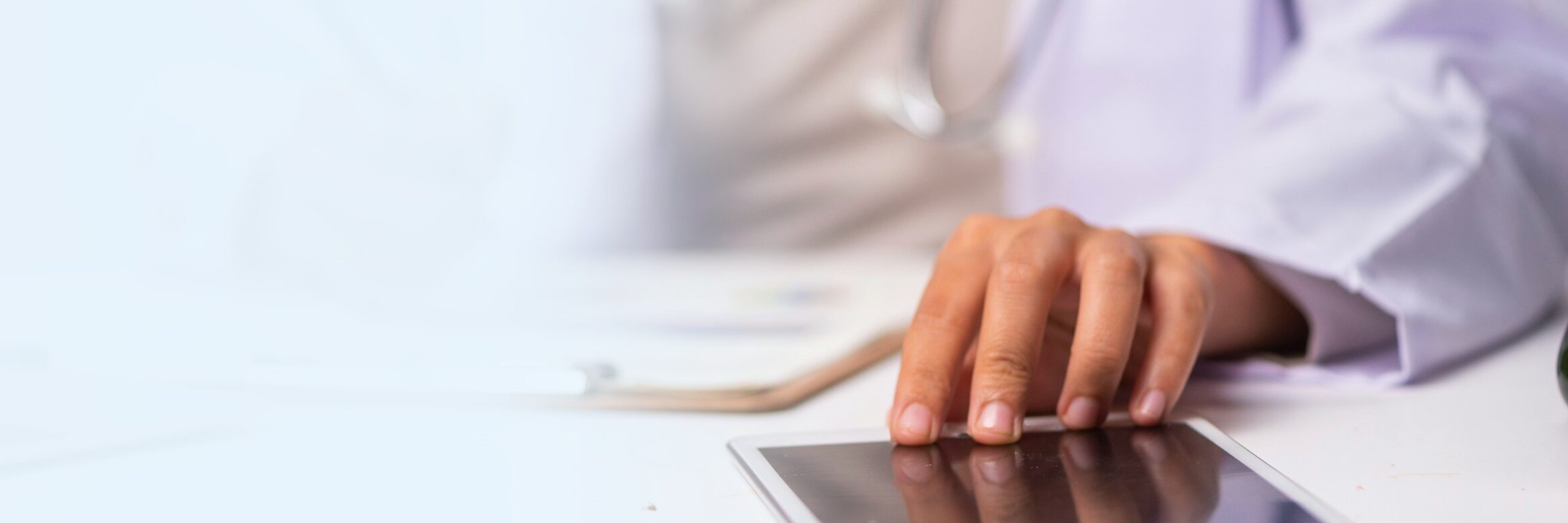 A clinician writing on a patient chart and using a tablet, tied to the 2027 Medicare Physician Fee Schedule and remote care.