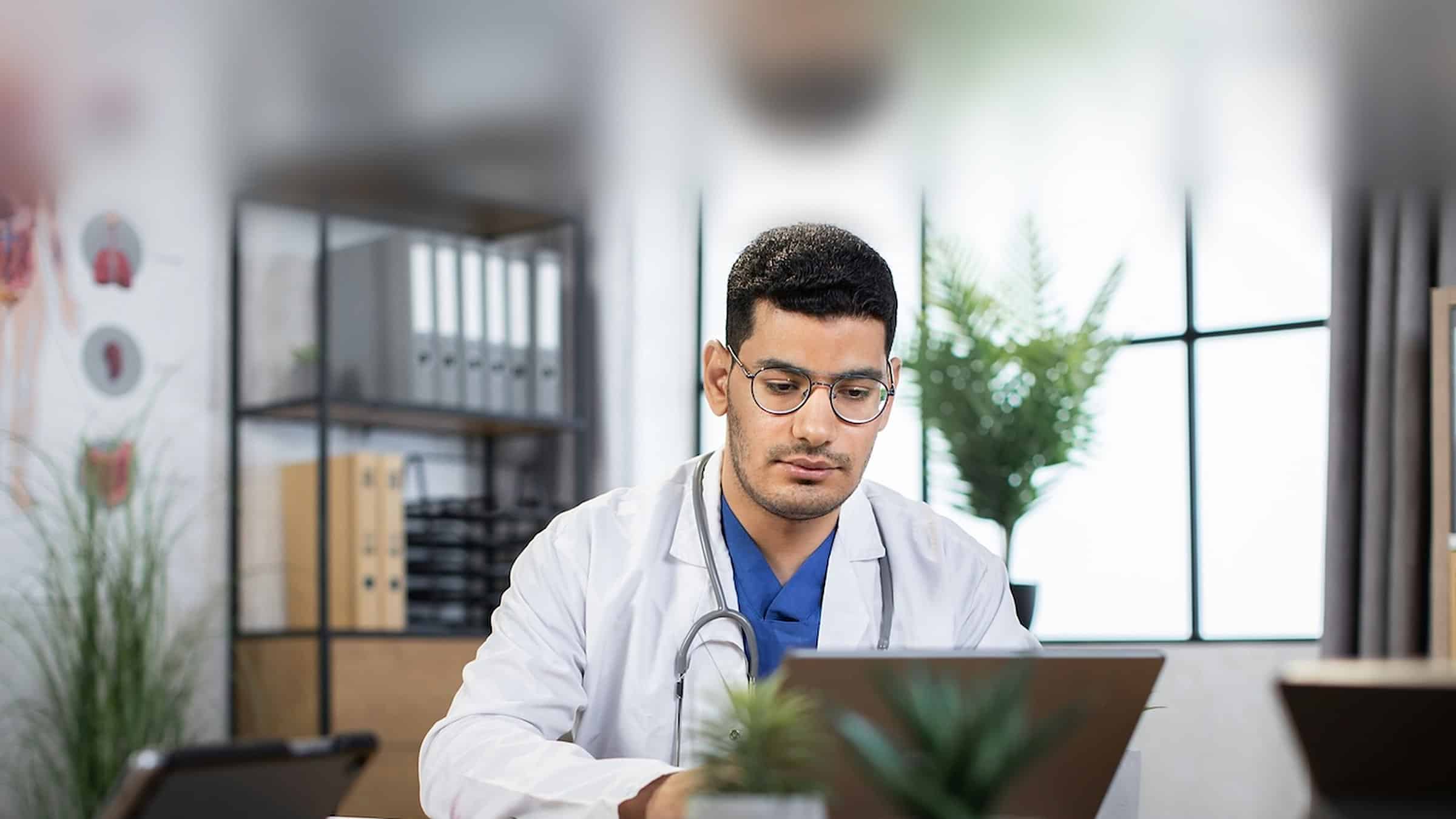 Physician reviewing chronic care management documentation on a laptop